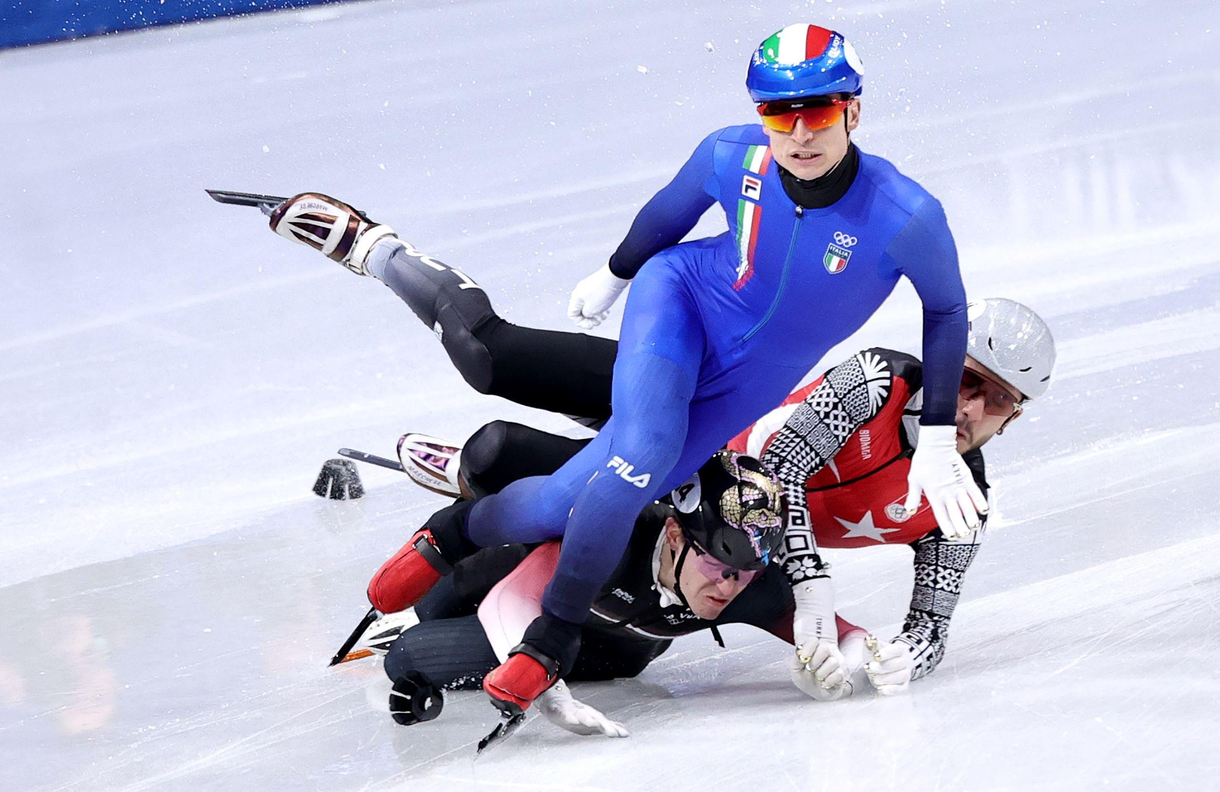 Skandali i bizarnosti na Zimskim olimpijskim igrama 2026. 9 Furkan Akar iz Turske i Rejnis Berzinjs (dole) iz Letonije padaju pored Pjetra Sigela iz Italije u muškim kvalifikacijama na 500 metara na takmičenju u brzom klizanju na kratkim stazama u Milanu