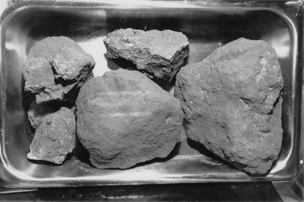 Several grey rocks of different sizes are sitting in a metal tray. 
