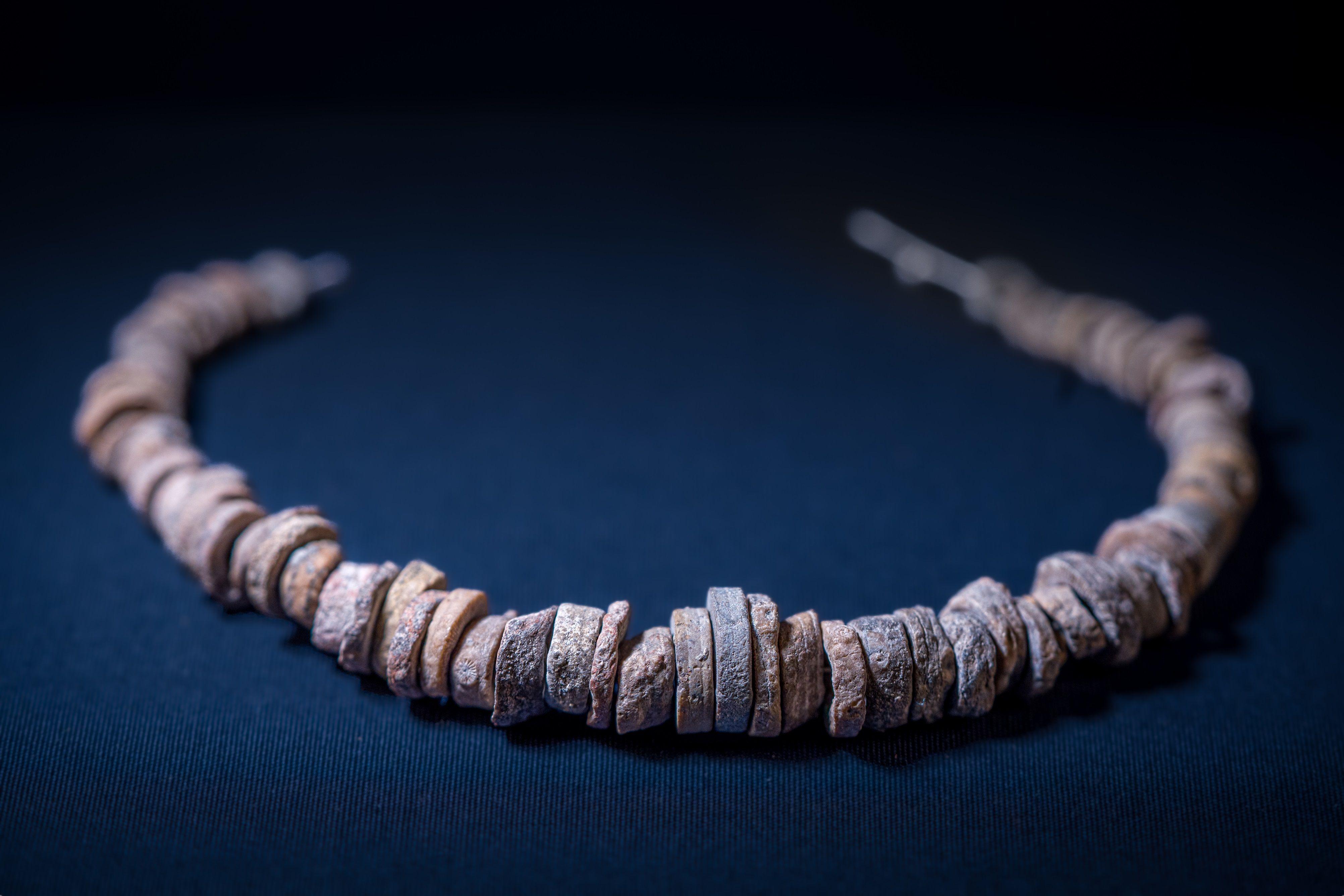 Ogrlicana plavoj tkanini, sastavljena je od pojedinačnih prstenova fosila nanizanih na kanapu