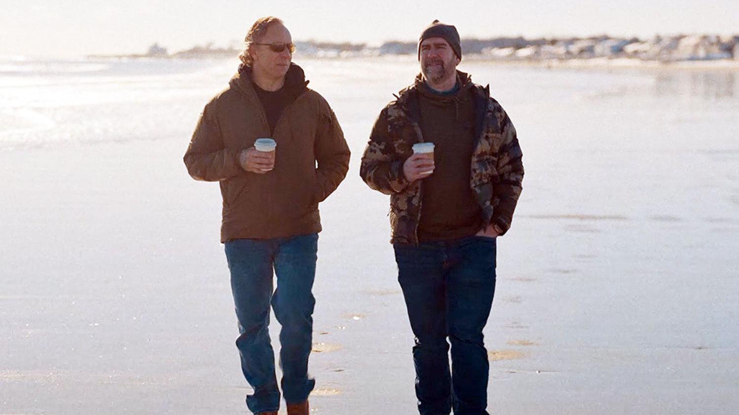 Obična cigla pomogla da se pronađe godinama zlostavljana devojčica 6 dvojica muškaraca šetaju plažom, u rukama im je kafa. Obojica nose plave pantalone i smeđe jakne.