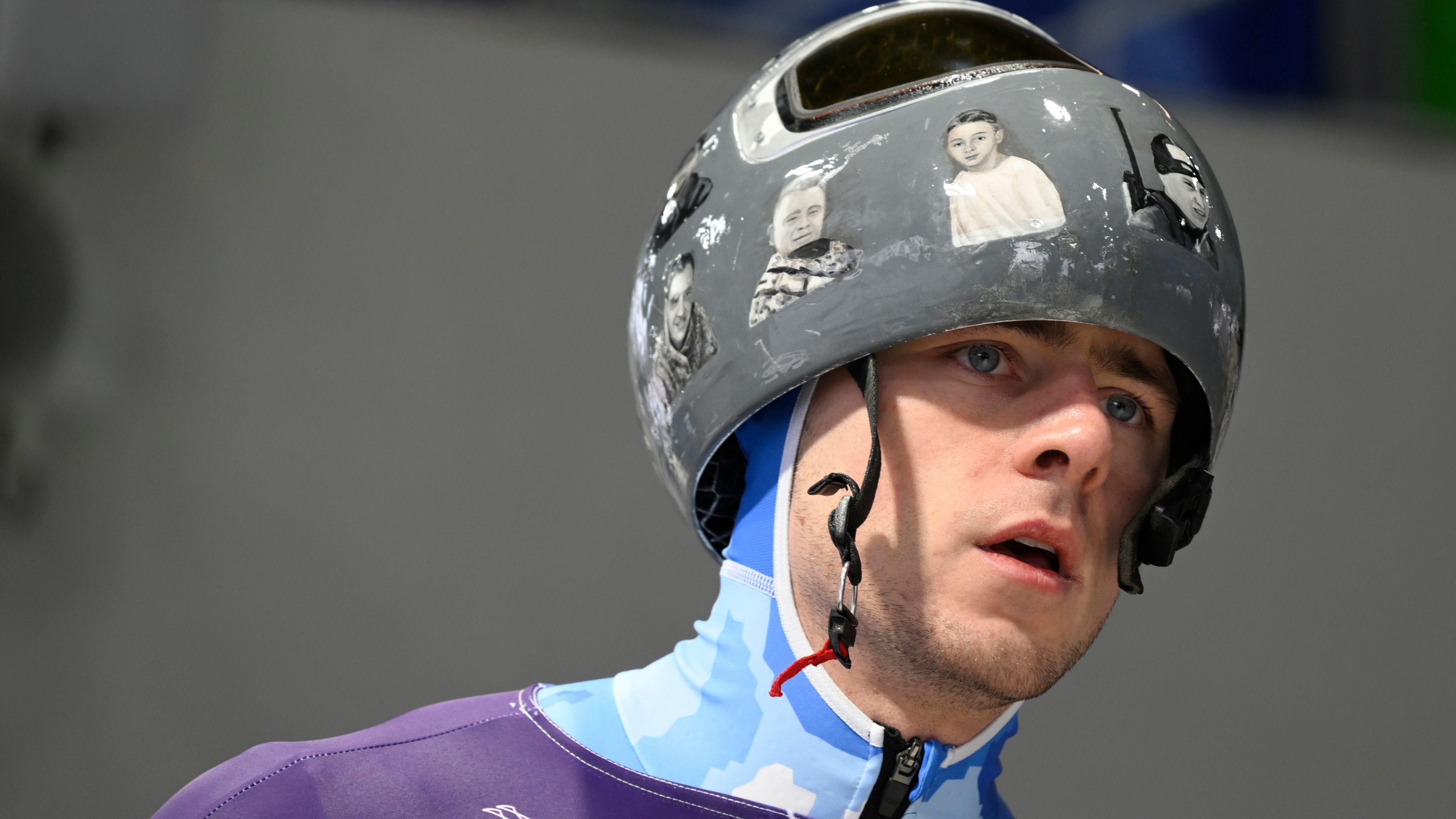 Vladislav Geraskevič nosi kacigu sa slikama poginulih u ratu u Ukrajini na stazi za skeleton u Kortini, u Italiji, na Zimskim olimpijskim igrama