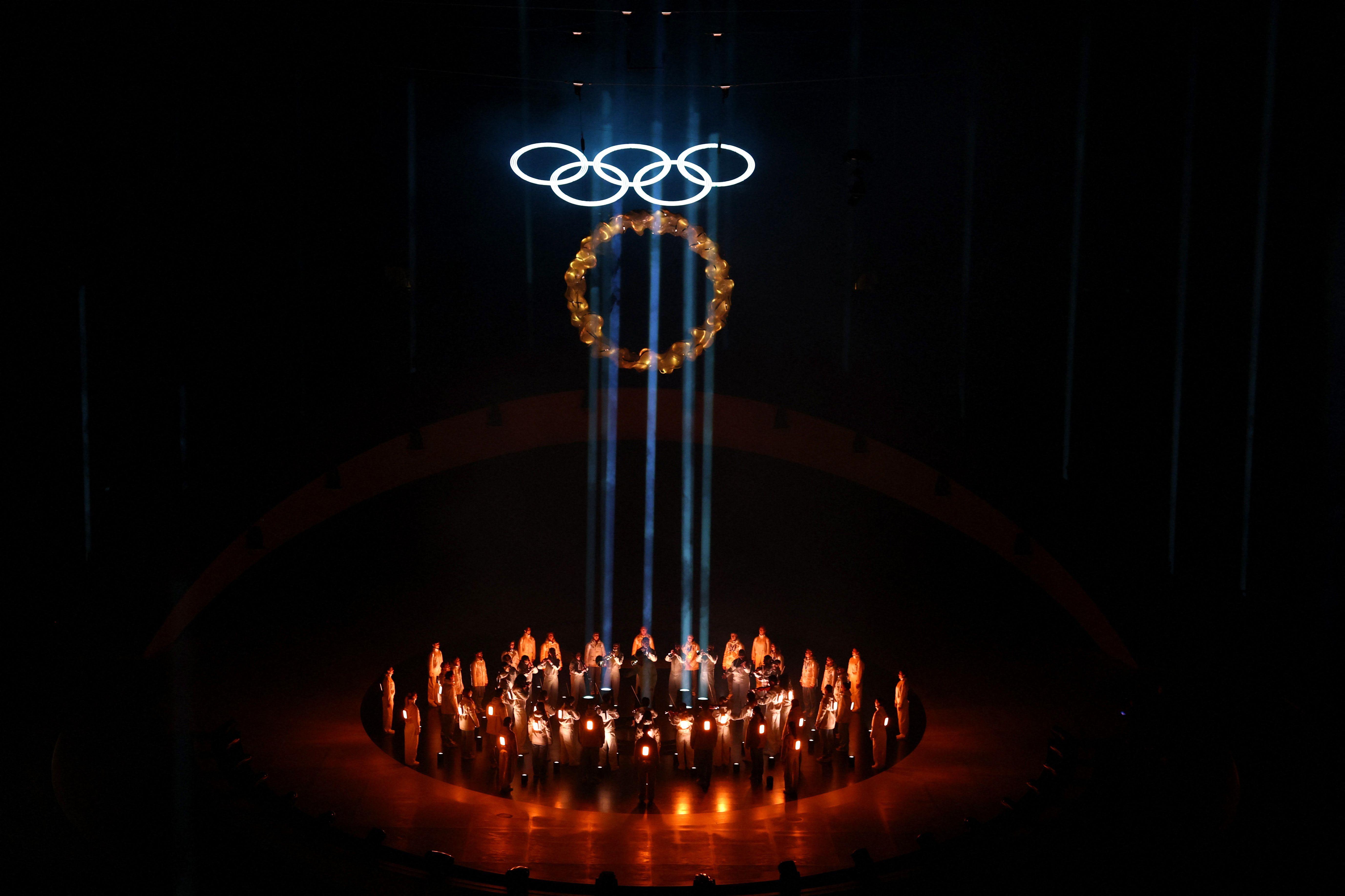 Zatvaranje Zimskih olimpijskih igara kroz fotografije 2 Grupa ljudi u krugu, u smeđim svetlima, iznad njih olimpijski krugovi