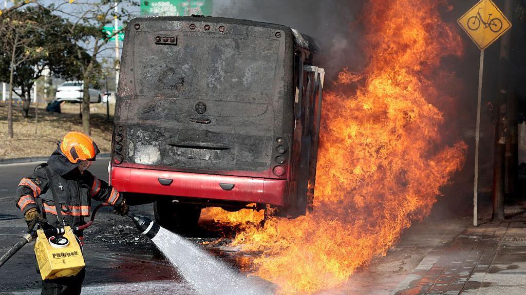 Vatrogasac vodom gasi zapaljeni autobus u Meksiku