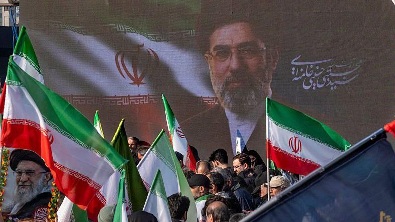 'Odsečete jednu glavu, izraste nova': Kako su vladari Irana stvorili sistem koji ih održava na vlasti 1 veliki poster iranskog vrhovnog vođe Ajatolaha Modžtaba Hamneija ispred koga su ljudi sa zastavama