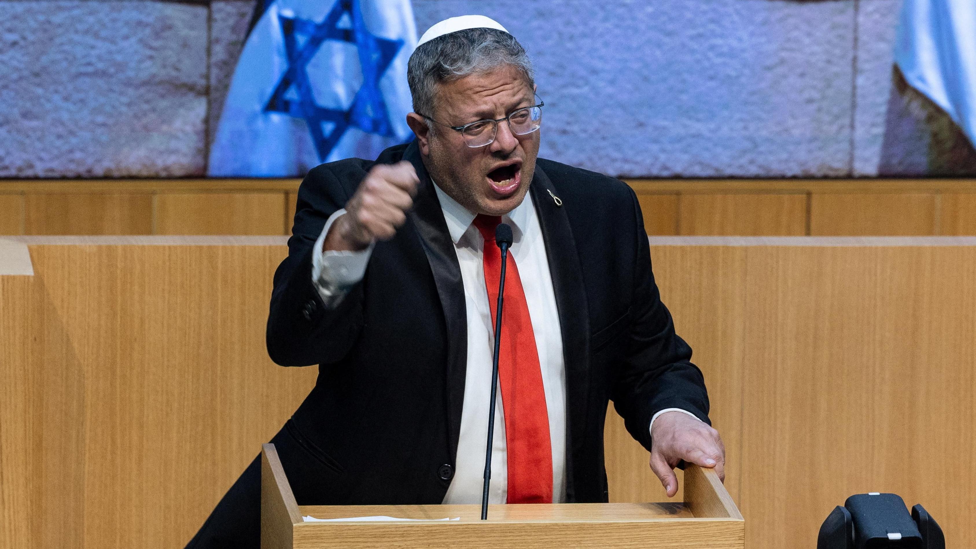 Izrael uvodi smrtnu kaznu za Palestince osuđene za 'terorističke napade' 1 Itamar Ben-Gvir, u crnom odelu sa crvenom kravatom, podignutom desnom rukom, za govornicom