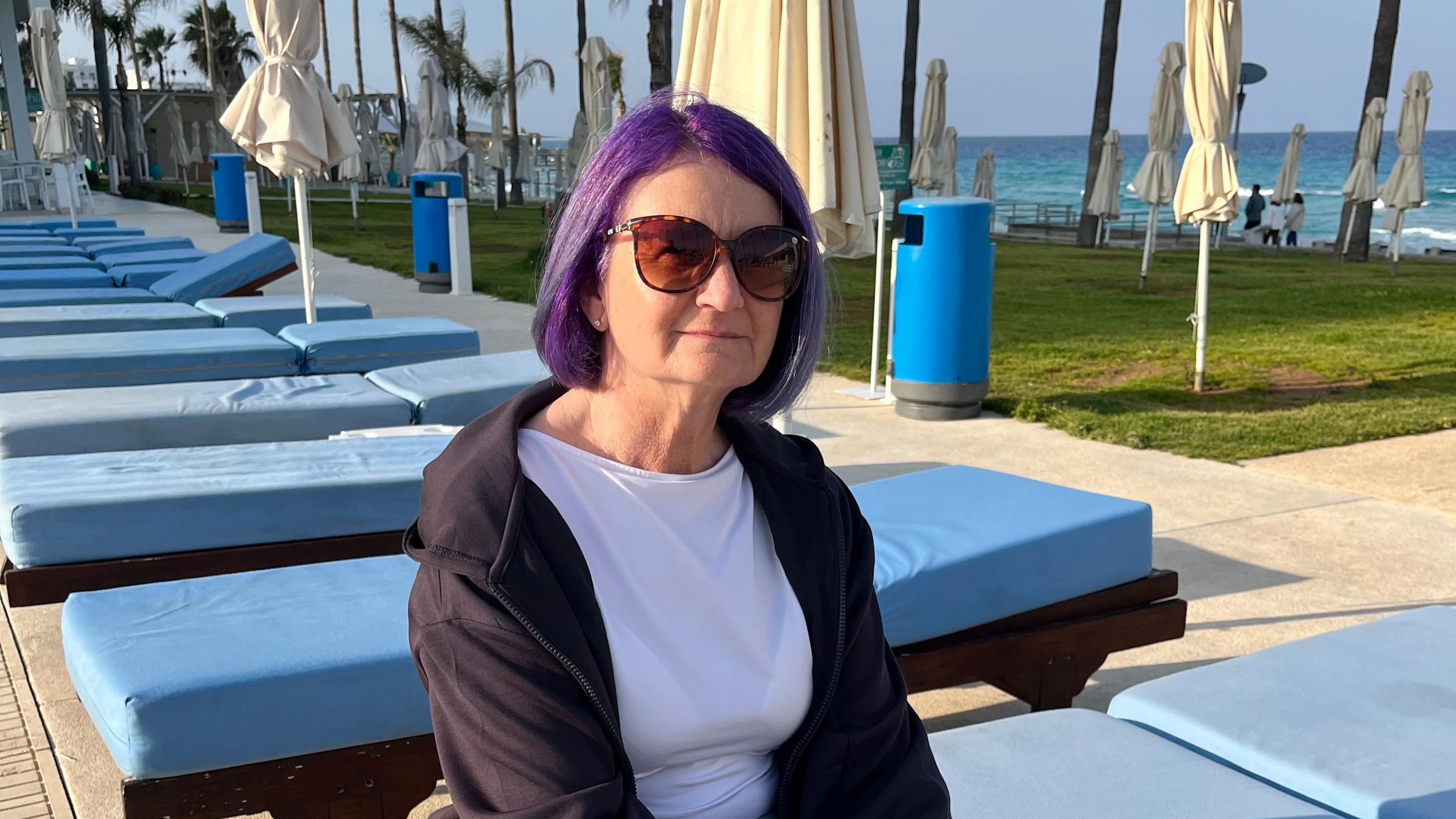 'Daju besplatno pivo': Ima li turista na Kipru i plaše li se rata na Bliskom istoku 4 British ex-pat Victora O'ffe sitting on a lounge chair with multiple empty lounge chairs from behind