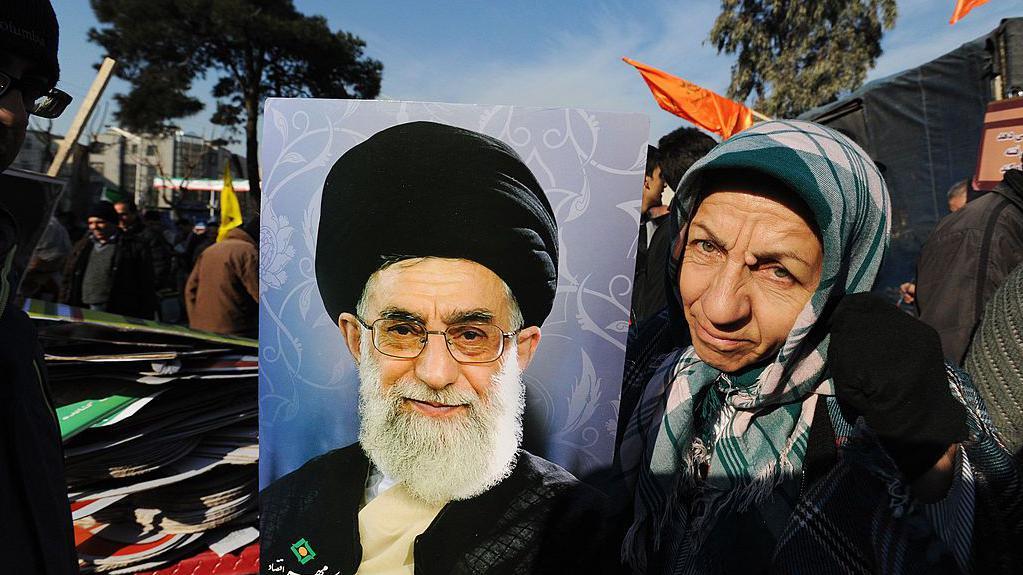 Ajatolah Hamnei: Kako je iranski vrhovni vođa držao vlast čeličnim stiskom 2 Iranka pozira sa portretom vrhovog lider Hamneija