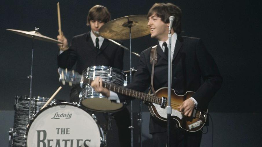 Od Bitlsa do kantri albuma: Legendarni bubnjar Ringo Star za BBC 3 Ringo Star svira bubnjeve iza , basiste i pevača Pola Makartnija 1964. godine.