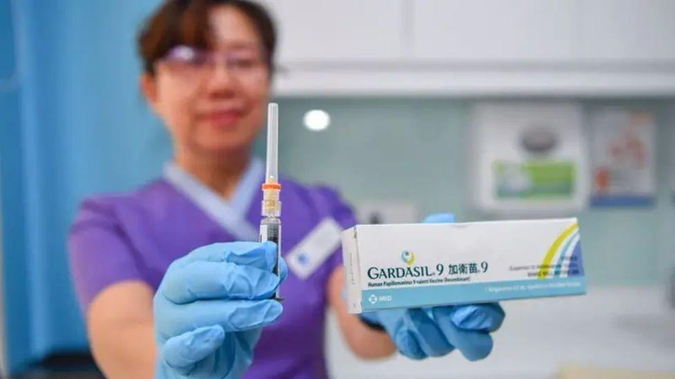 žena drži Gardasil 9 vakcinu