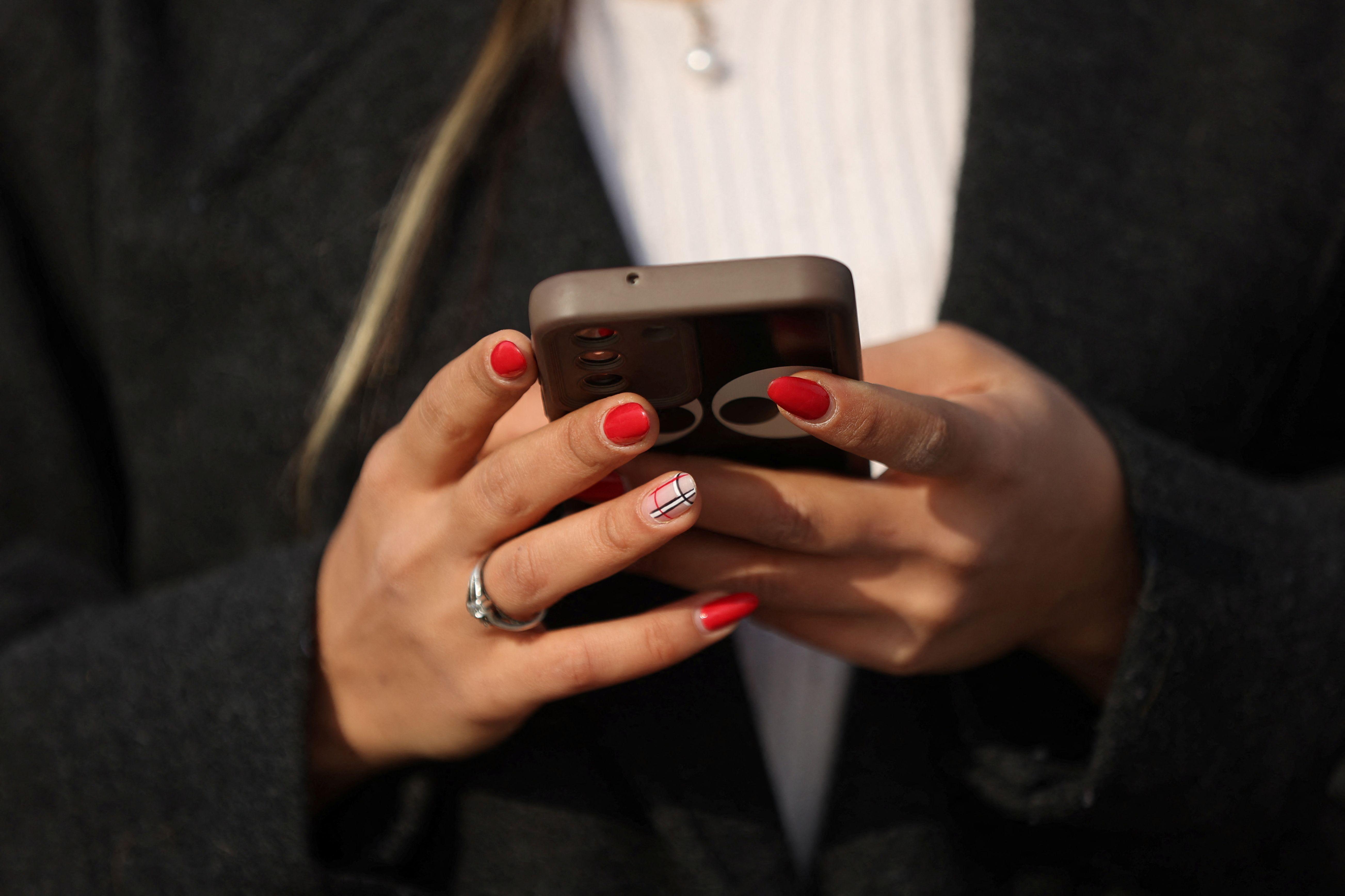 'Postala mi je najbolji prijatelj': Nove aplikacije koje žele da 'optimizuju' ožalošćenost 4 mobilni telefon u rukama žene sa nalakiranim noktima
