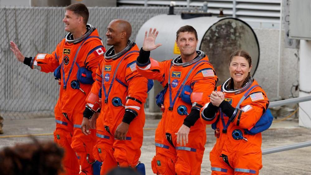 Četiri astronauta u narandžastim odelima