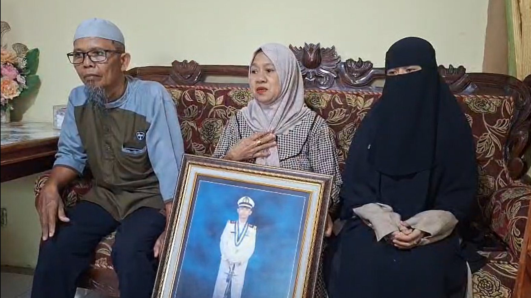 'Ne pucajte, musliman sam': Kapetan u zarobljeništvu somalijskih pirata 6 Stariji muškarac, žena sa maramom oko glave sa slikom čoveka u kapetanskoj uniformi u rukama i druga žena skroz umotana u crno