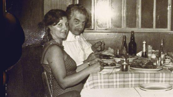 Crno-bela fotografija muškarca i žene za stolom
