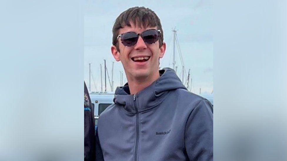 'Osećam se usamljeno i napušteno': Britanac u ruskom zatočeništvu za BBC 1 Hejden Dejvis se osmehuje u kameru noseći naočare za sunce u civilnoj odeći na fotografiji snimljenoj pre nego što je bio u ruskom zarobljeništvu