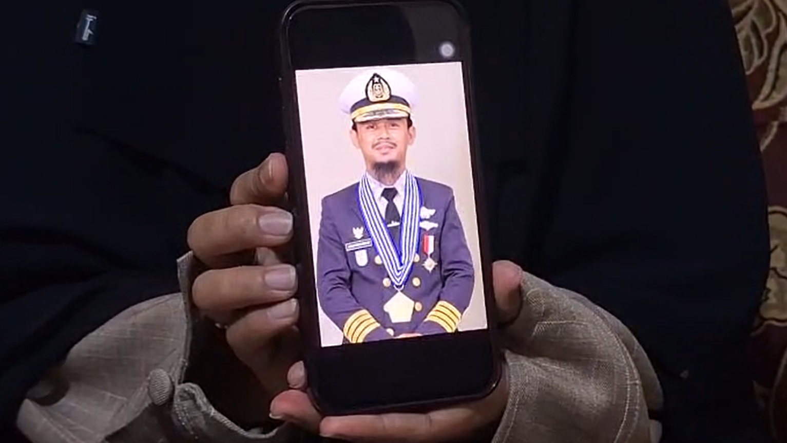 'Ne pucajte, musliman sam': Kapetan u zarobljeništvu somalijskih pirata 3 Žena drži telefon na čijem je ekranu slika muškarca u kapetanskom odelu sa ordenom oko vrata