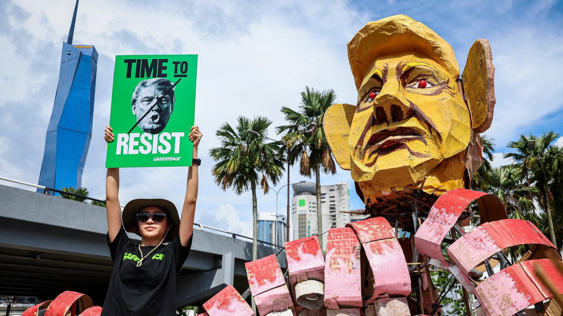 Prvi maj širom sveta: Protesti, suzavac i rejv 6 Žena drži natpis „Vreme je za otpor“ pored velike lutke sa likom američkog predsednika Donalda Trampa u Kuala Lumpuru, Malezija.