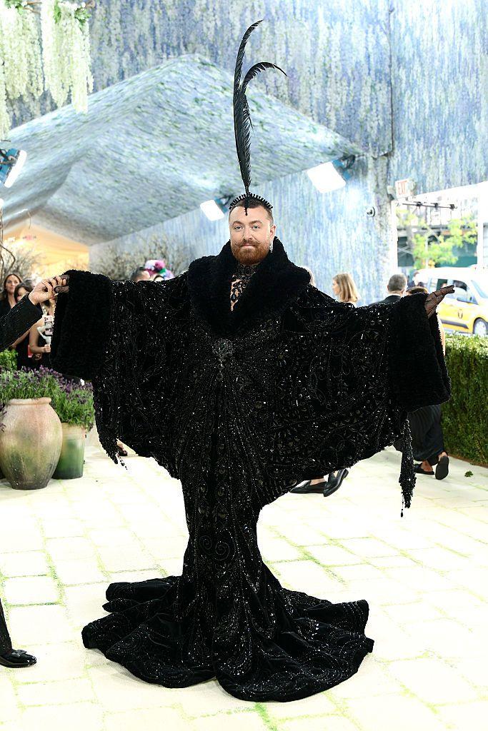 Met Gala 2026: Perje, jedrenjak na Madoninoj glavi, Bed Bani kao starac 23 Sam Smit se pojavio u crnoj mantil-haljini, na glavi je nosio ukras s crnim perjem