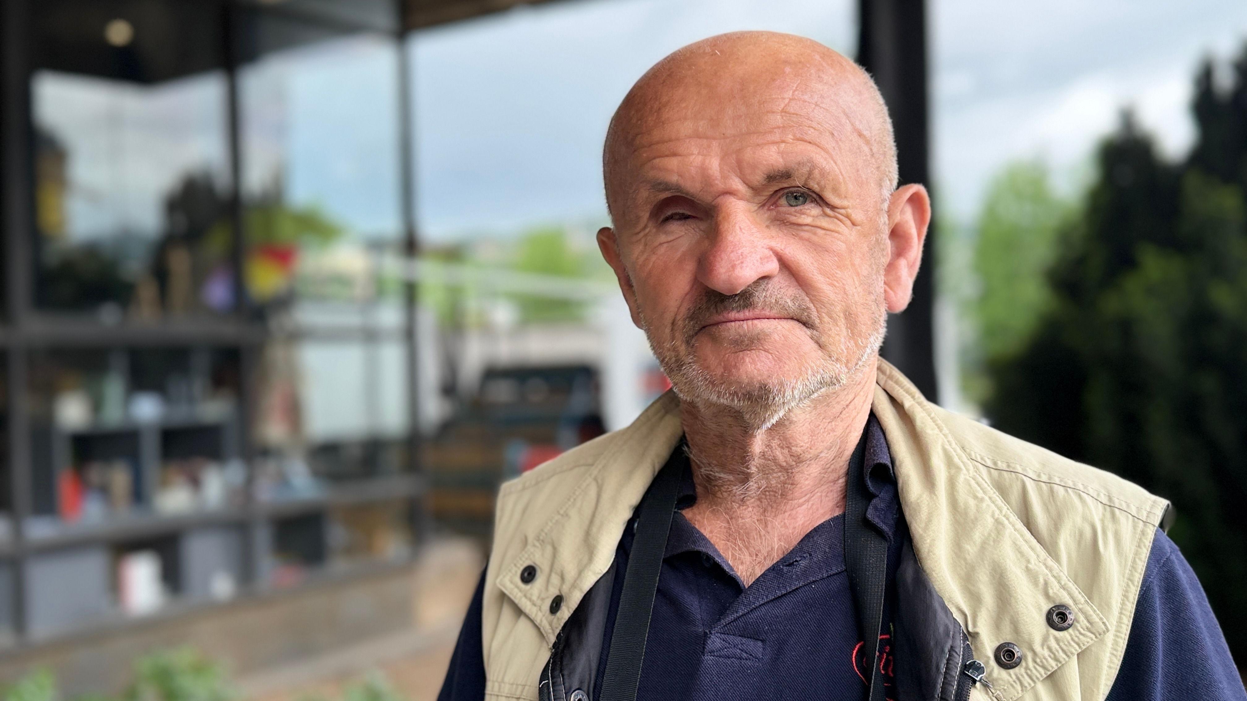 Pomama za sličicama fudbalera u Bosni: 'Menjaža' u muzeju, nestašice na trafikama 3 Muškarac gleda u kameru, stariji je, ćelav, ima plavu majicu i bež prsluk