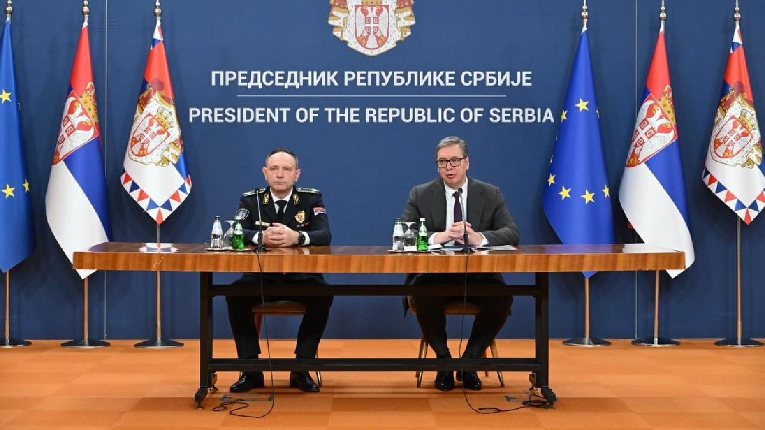 Dosadašnji šef beogradske policije pod istragom zbog 'prikrivanja' zločina 2 Dragan Vasiljević u uniformi sedi levo i Vučić u odelu sedi desno, ruku naslonjenih na sto, iza njih su zastave Srbije i EU