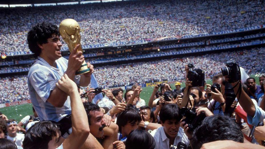 'Meksički navijački talas' koji nije meksički i zašto ga neki ne vole 3 Argentinski kapiten, Dijego Maradona, drži Svetski kup u rukama i slavi osvajanje turnira 1986. godine na prepunom stadionu. Ljudi ga fotografišu. U pozadini su hiljade ljudi na tribinama i delić fudbalskog terena