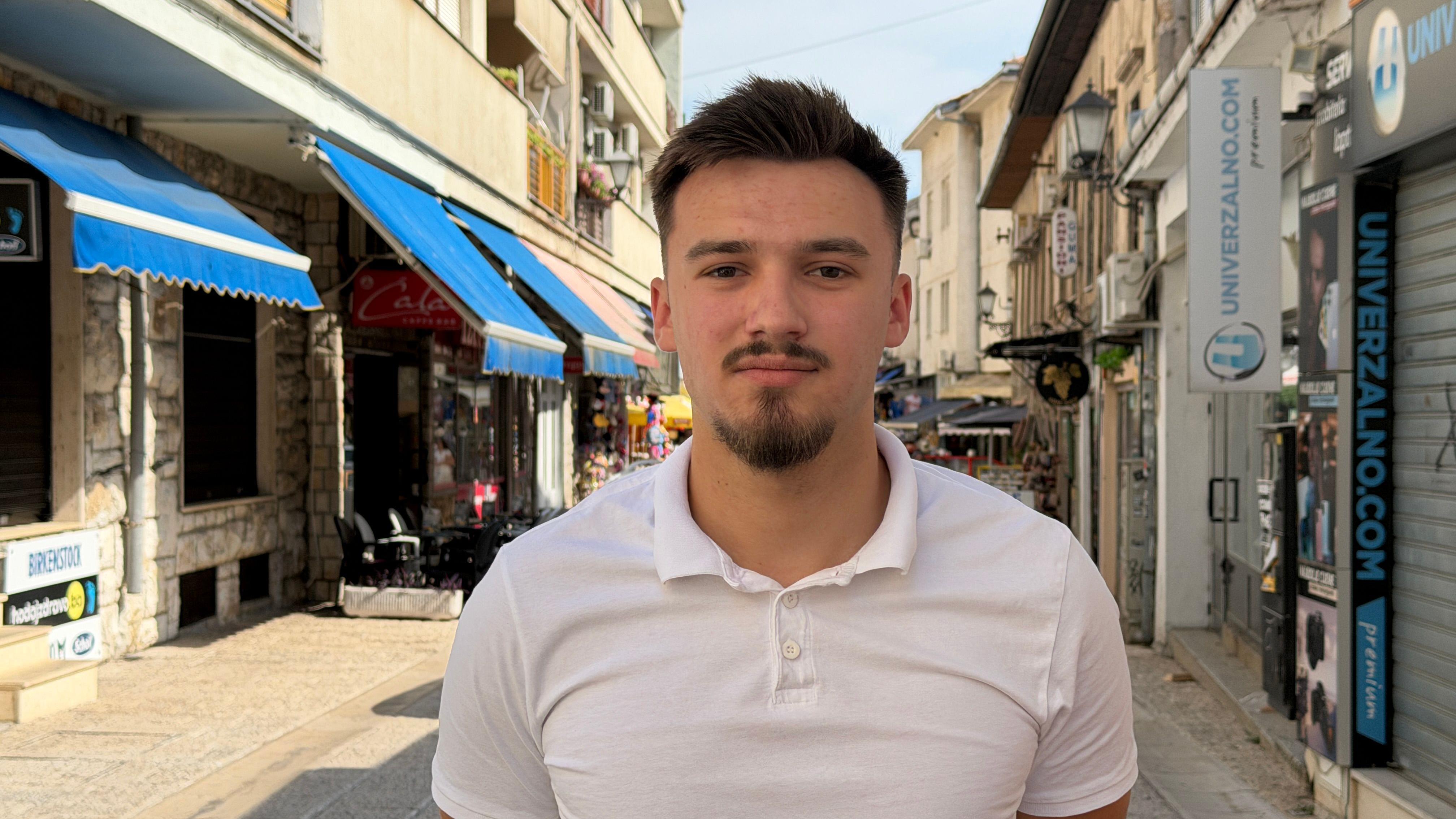 Bosna i Hercegovina - zemlja gde se više navija za komšiluk, nego za domovinu 5 mladić u beloj majici stoji na ulici i gleda u kameru