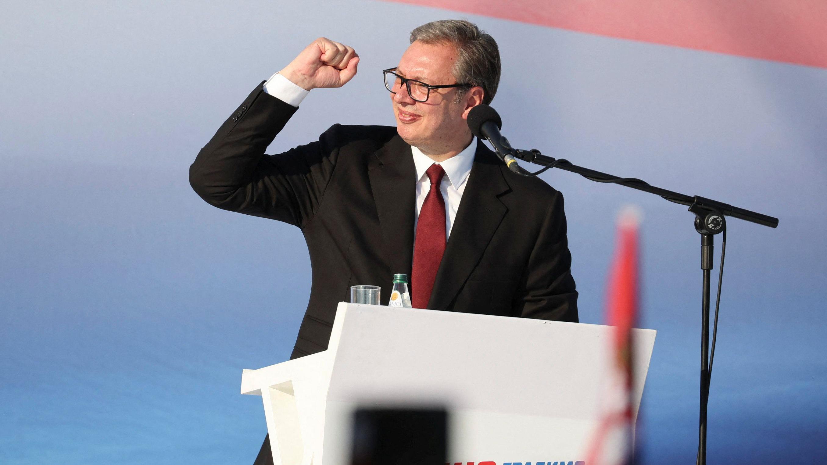 Predsednik Srbije u odelu tamnom i beloj košulji drži pesnicu u vazduhu na mitingu