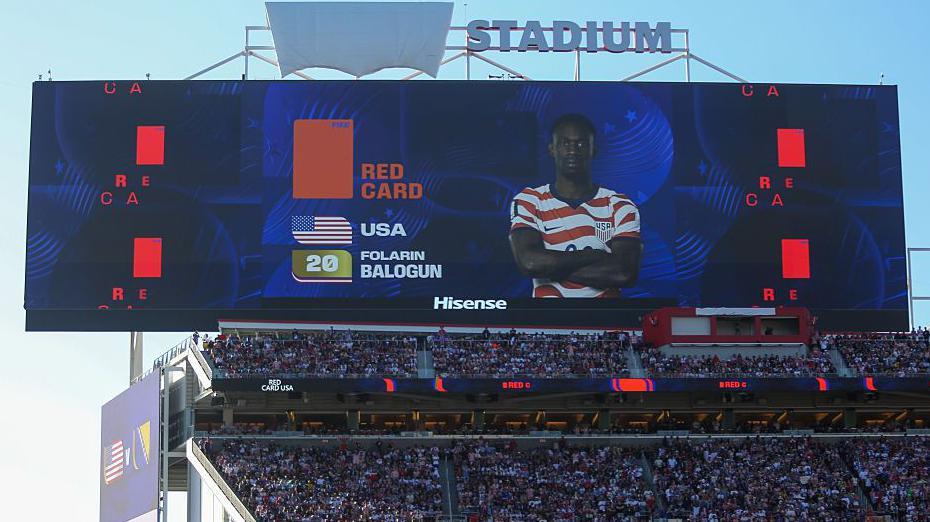 Skandal na Mundijalu: Tramp potvrdio da je tražio poništavanje crvenog kartona fudbaleru SAD 4 pogled na veliki ekran na stadionu, na njemu je lik fudbalera Balogana