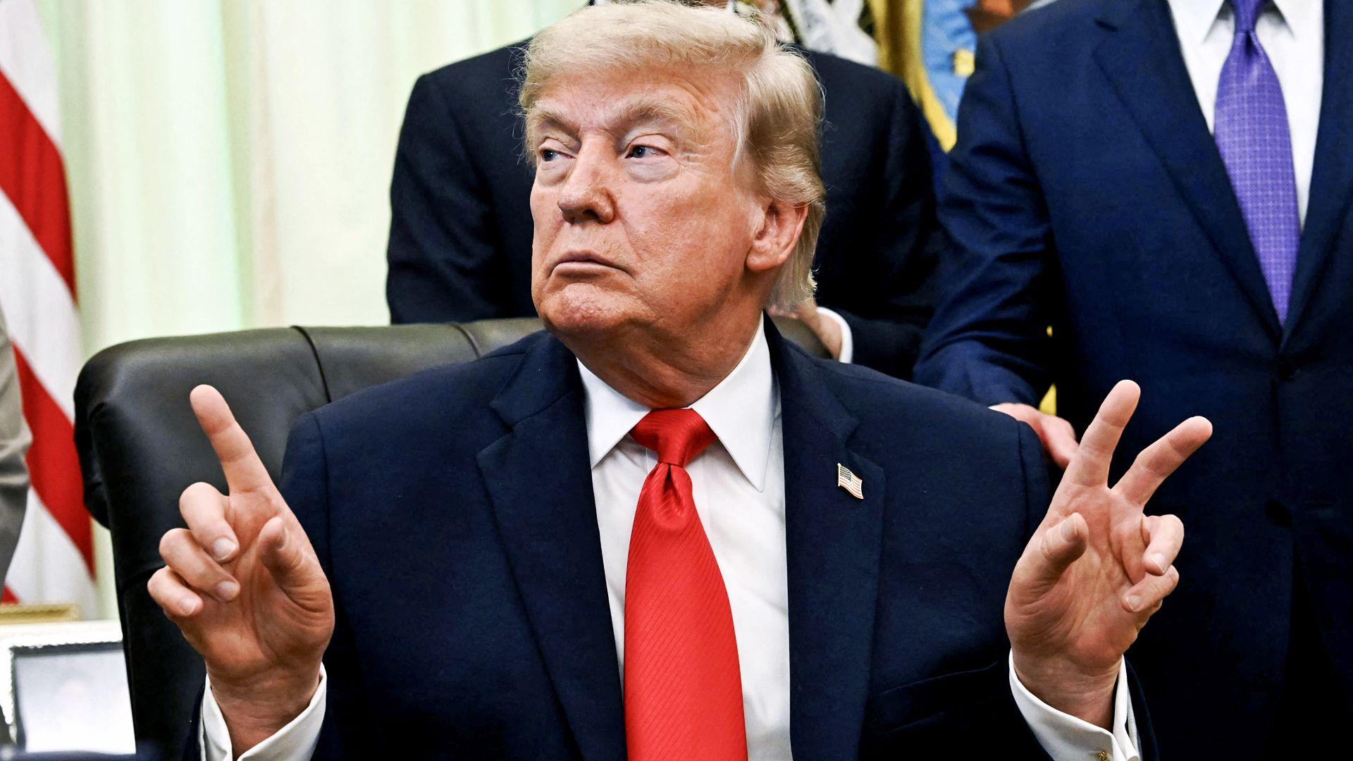 'Para na paru': Tramp se dodatno obogatio od trgovanja kriptovalutom 1 Donald Tramp u teget odelu sa crvenom kravatom podignutih ruku