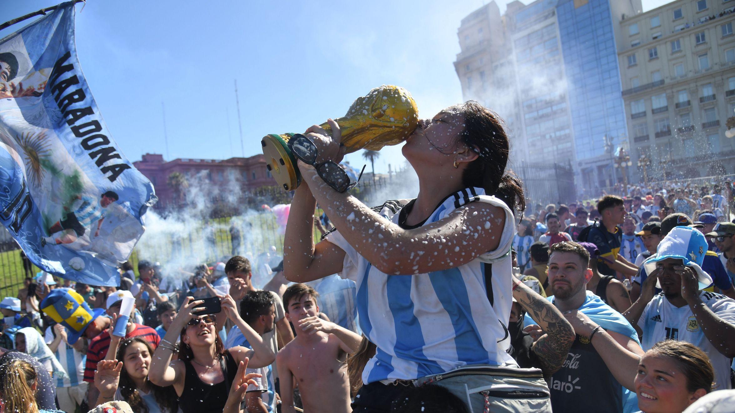 Tamo gde je fudbal više od života, a Maradona i Mesi u panteonu najvećih 2 Slavlje navijača u Buenos Ajresu, argentinski navijali, navijači argentine, argentinka ljubi repliku trofeja svetskog fudbalskog šampiona