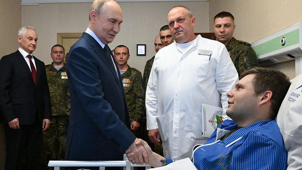 Na fotografiji Vladimir Putin se rukuje sa vojnikom u bolničkom krevetu, koji ima plavu pidžamu, u vojnoj bolnici u Moskvi u oktobru 2025. godine.