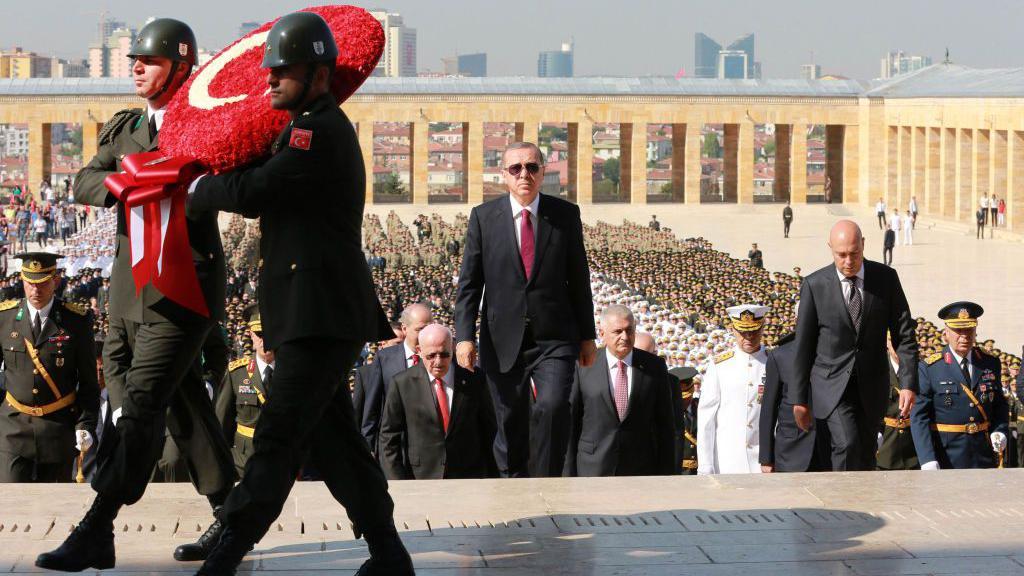 Pokušaj puča: Kako je Erdogan promenio Tursku protekle decenije 6 Predsednik Redžep Tajip Erdogan penje se stepenicama ankarskog mauzoleja Ataturk tokom ceremonije povodom Dana pobede 30. avgusta 2016. godine, okružen vladinim zvaničnicima dok vojnici nose venac u obliku turske zastave