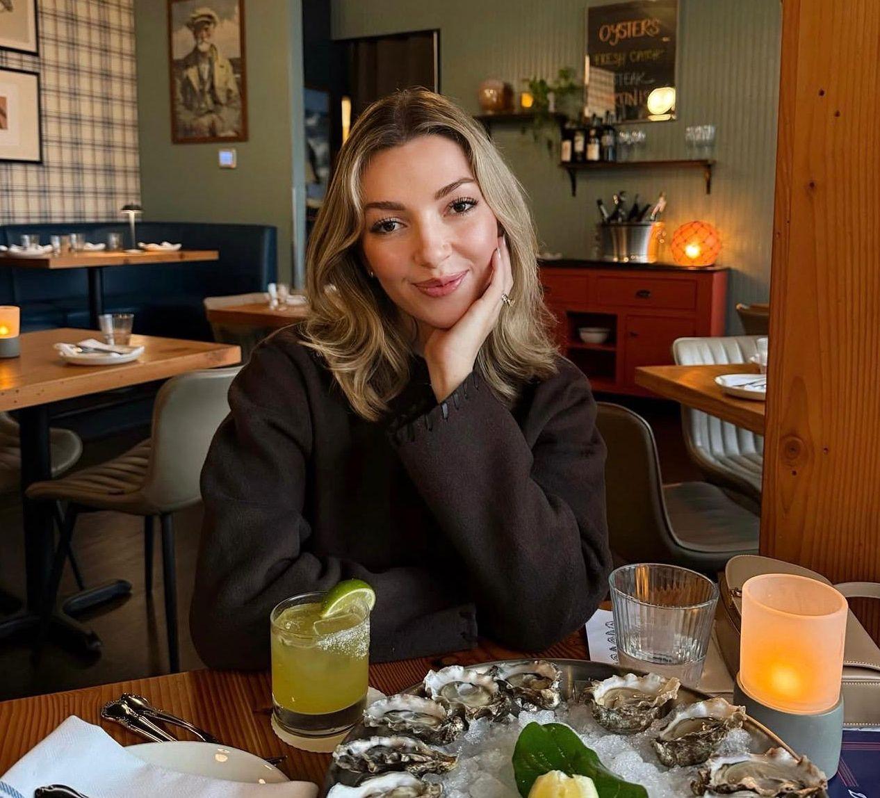 Uzimanje koktela suplemenata svaki dan može da vam škodi 2 Ginger Smith sits at a restaurant table, with a cocktail and a plate of oysters