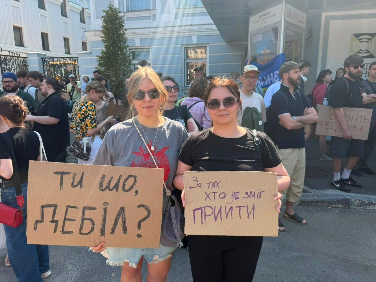 Dve demonstrantkinje u Kijevu drže transparente na kojima piše: „Šta radiš, idiote?“ i „Ovo je za sve one koji nisu mogli da budu ovde“