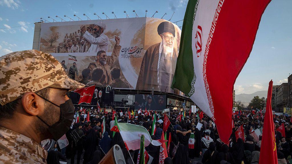 Uprkos busanju u prsa, Tramp nema bolju opciju od pregovora sa Iranom: BBC urednik 1 Stotine ljudi sa iranskim zastavama i velikim plakatom sa slikom Alija Hamneija