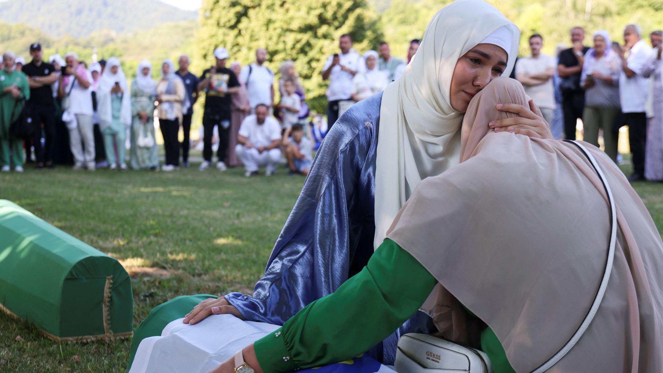 Pomen žrtvama genocida u Srebrenici, pisac Vladimir Arsenijević tvrdi da je napadnut u Beogradu 1 Devojka i starija žena u zagrljaju rukama oslonjene na kovčeg obmotan zelenom i belom bojom