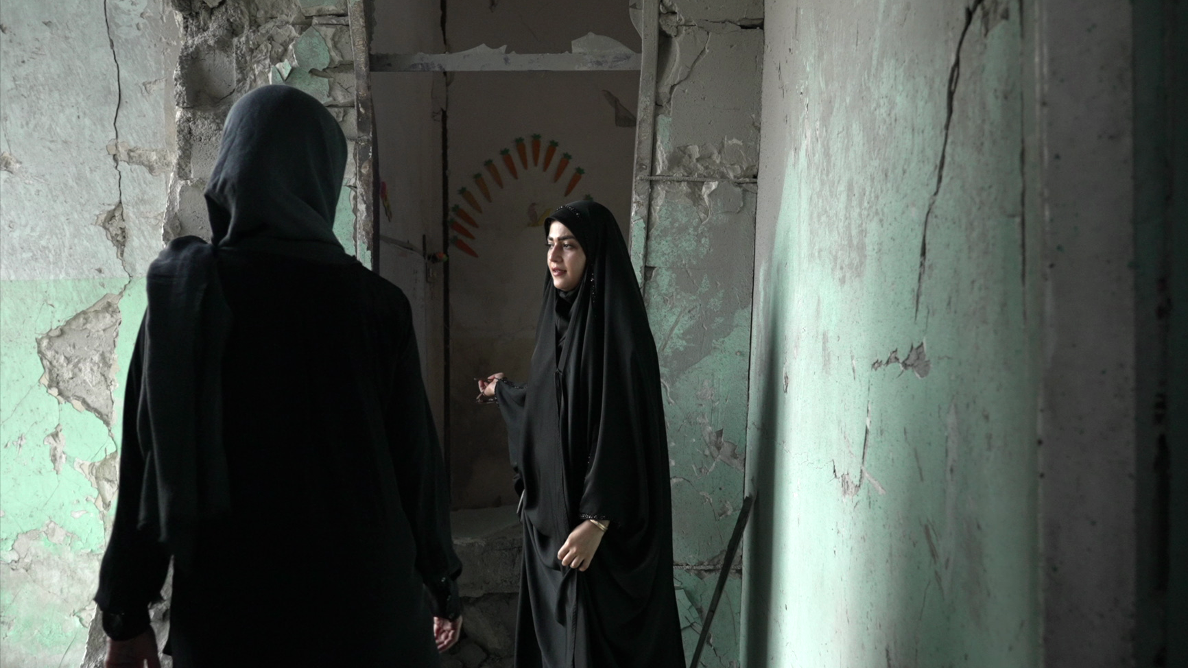 'Šta je bio njihov zločin?': BBC u poseti iranskoj školi u kojoj je stradalo 120 dece 3 Amaineh Nademi hoda preostalim hodnikom osnovne škole Šadžare Tajebeh u Minabu. Nosi crni čador i pokazuje novinarki BBC Naval Al-Magafi štetu na školi. Betonski zidovi su napukli i prethodno su bili ofarbani u pastelno zeleno.