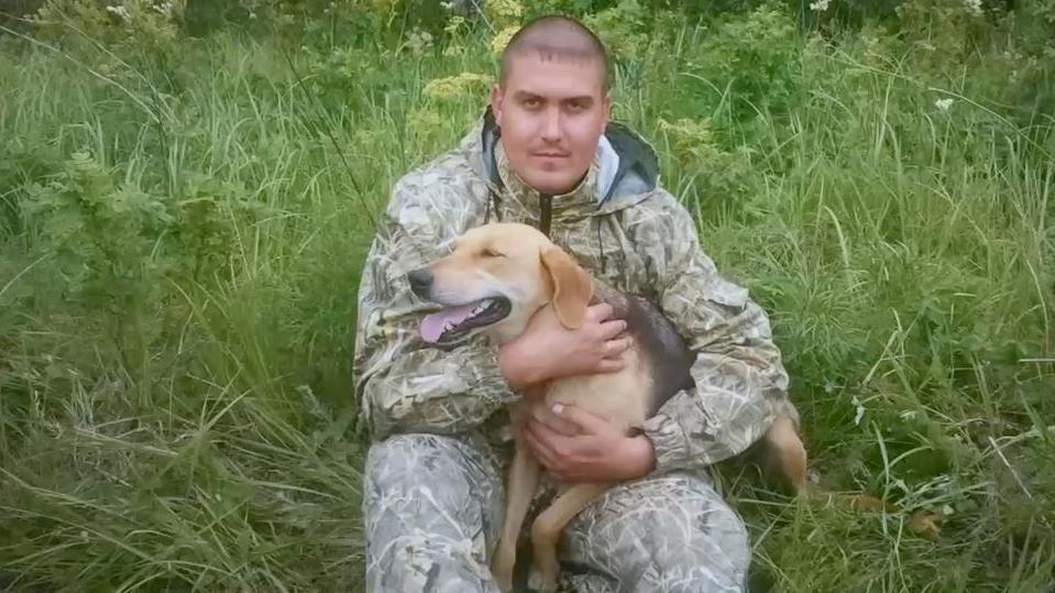 BBC razotkrio čuvare i zvaničnike ruskih 'zatvora za mučenje' u Ukrajini 9 Muškarac sa psom u rukama na travi u vojničkoj trenerci